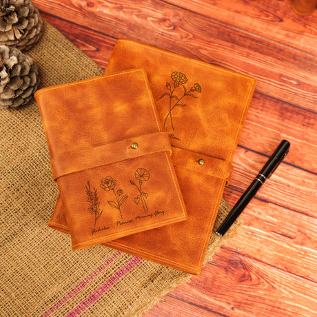 a pair of notebooks sitting on top of a wooden table