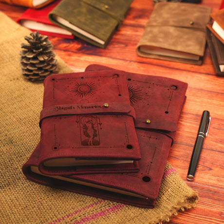 a pile of notebooks sitting on top of a wooden table