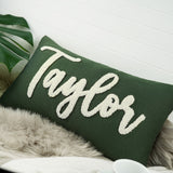 a green pillow with the word taylor on it