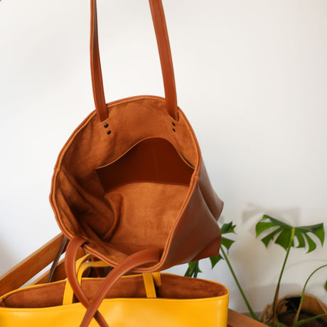 a yellow purse sitting on top of a wooden table