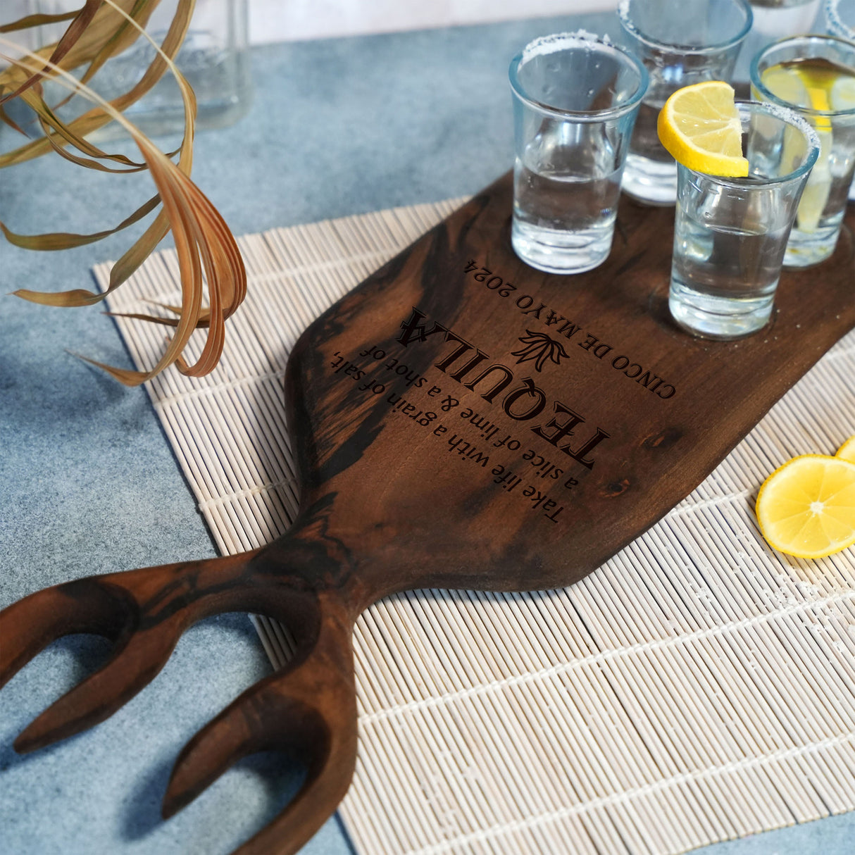 a wooden cutting board with glasses and lemons on it