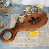 a wooden cutting board with glasses of water and lemons