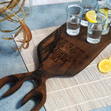 a wooden cutting board with some glasses on it