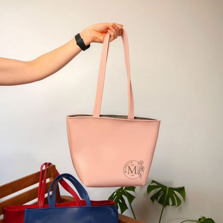 a person holding a pink and blue bag