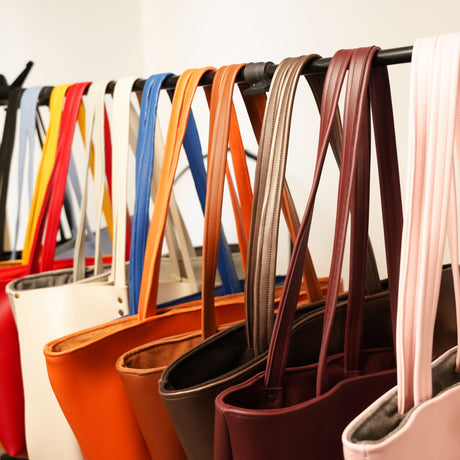 a row of purses lined up against a wall