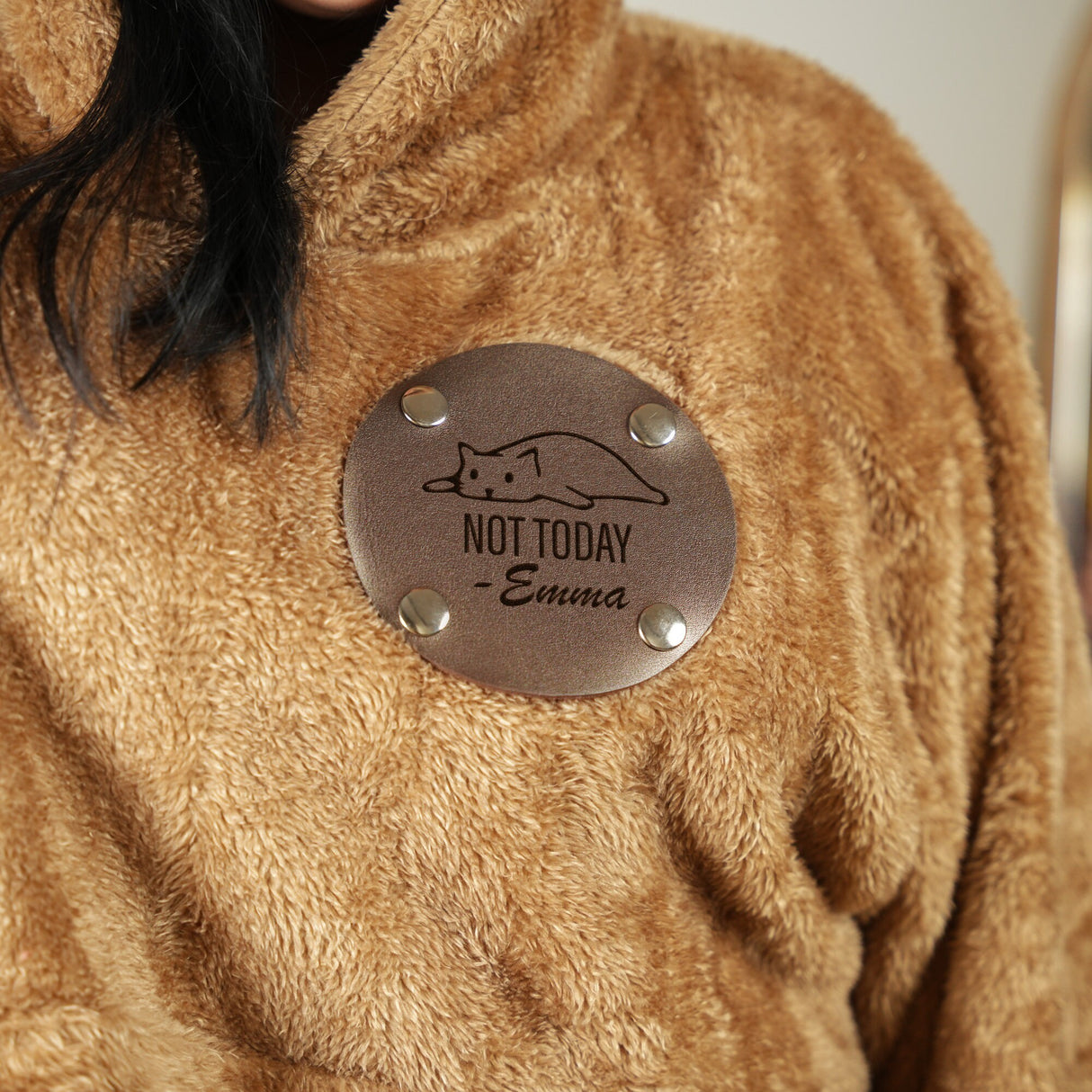 a woman wearing a brown coat with a badge on it