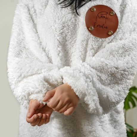 a woman wearing a white coat with a leather button