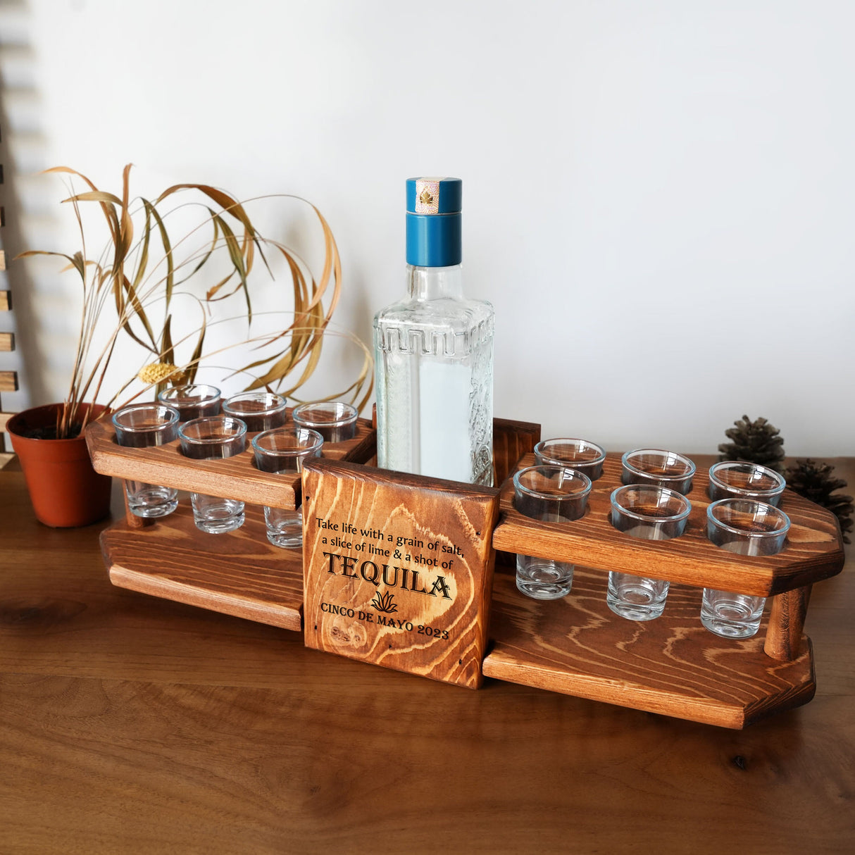 a wooden tray with glasses and a bottle on it
