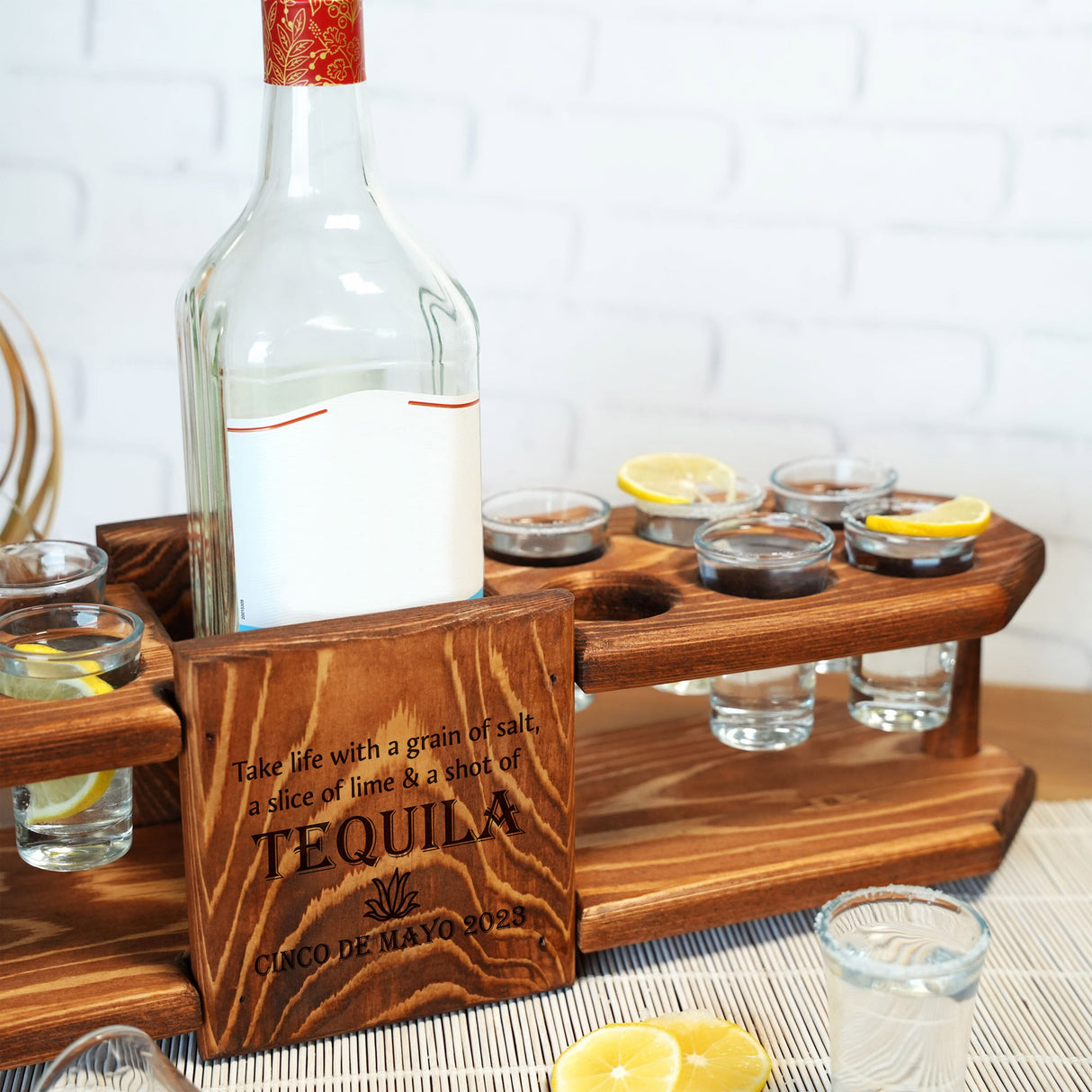 a bottle of tequila sitting on top of a wooden tray