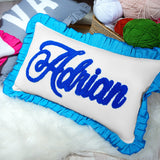 a blue and white pillow sitting on top of a pile of yarn