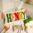 a pillow with the word henry on it next to a crochet set and