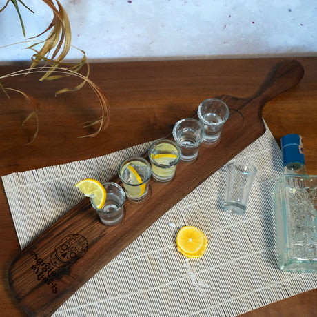 a wooden board with glasses and lemons on it