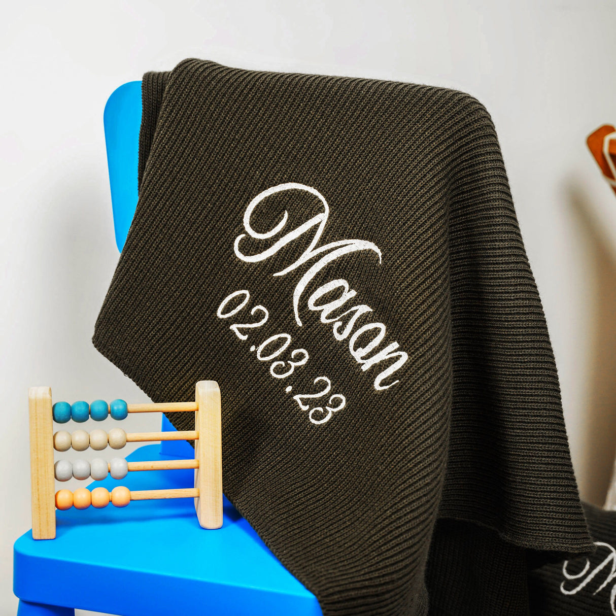 a personalized blanket sitting on top of a blue chair