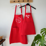 two red aprons hanging on a wall