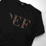 a black sweatshirt with a floral design on it