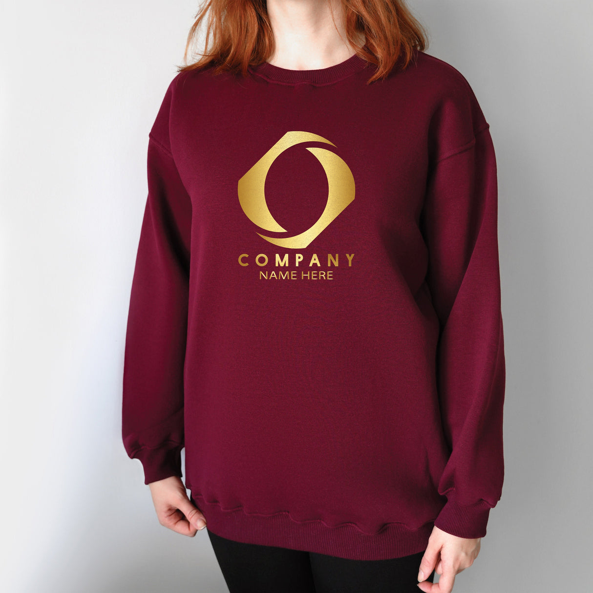 a woman wearing a burgundy sweatshirt with a gold company name on it