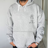 a man wearing a grey hoodie with a dog drawn on it