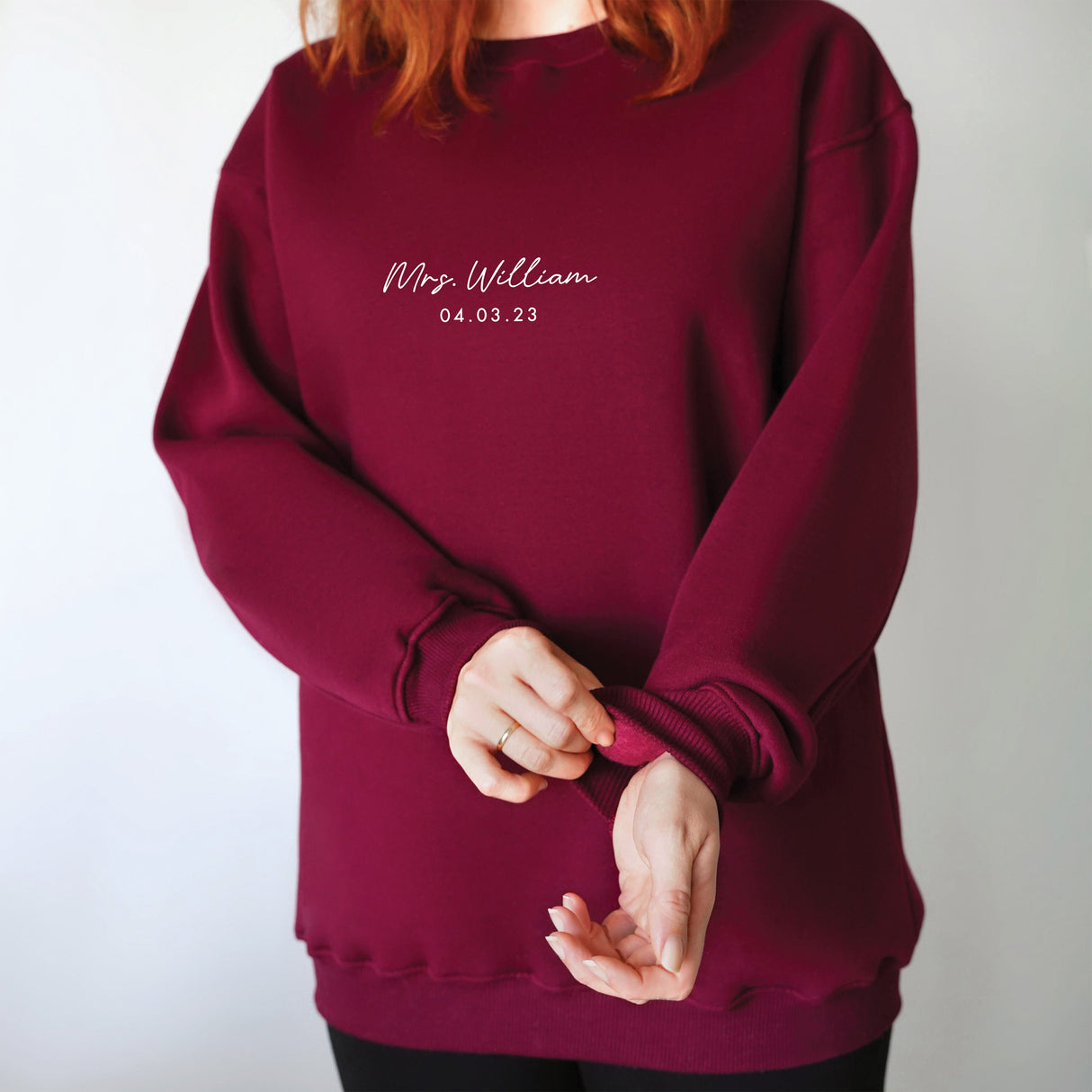 a woman with red hair wearing a maroon sweatshirt