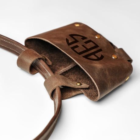 a brown leather bag with a logo on it