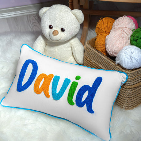 a teddy bear sitting next to a pillow with the word david on it