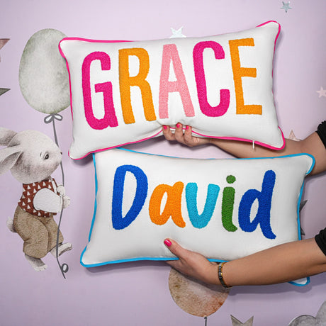 a woman holding two pillows that say grace and david