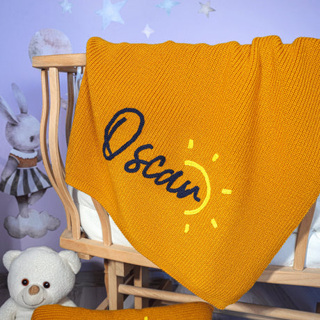 a baby crib with a yellow blanket and a white teddy bear