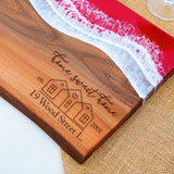 a wooden cutting board with a picture of a house on it