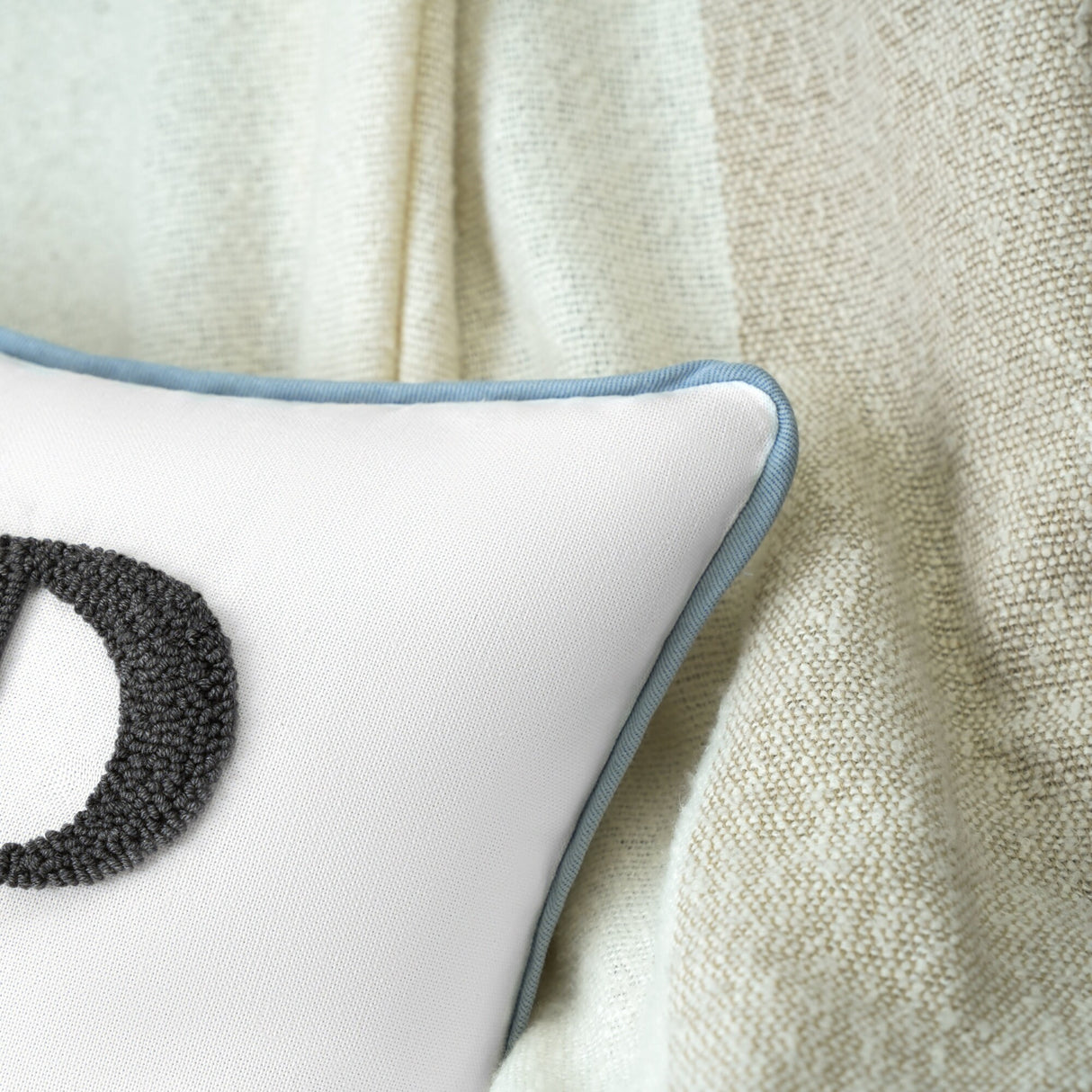 a close up of a pillow with a letter d on it