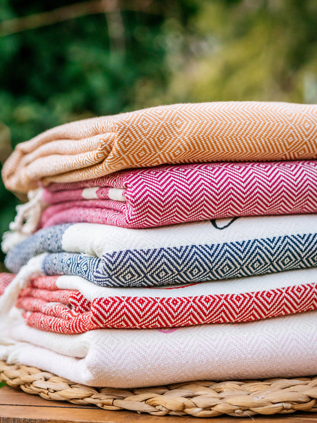 a stack of folded towels sitting on top of a wooden table