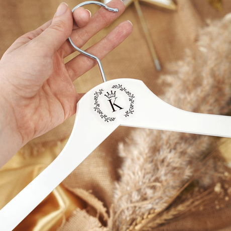 a person holding a white hanger with a letter k on it