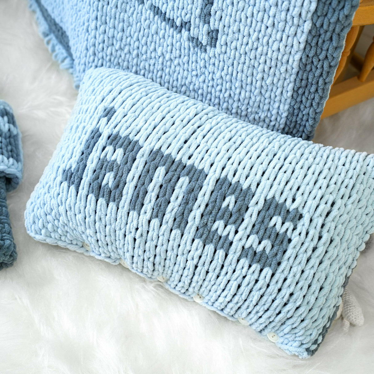 a blue knitted pillow sitting on top of a white rug