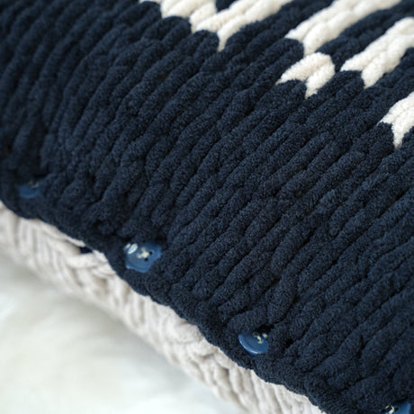 a close up of a knitted pillow on a bed