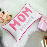 a pink and white pillow with the word mom on it