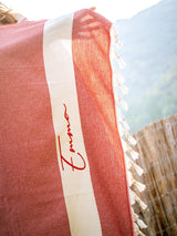 a red and white towel with a signature on it