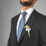 a man wearing a suit and tie with a boutonniere