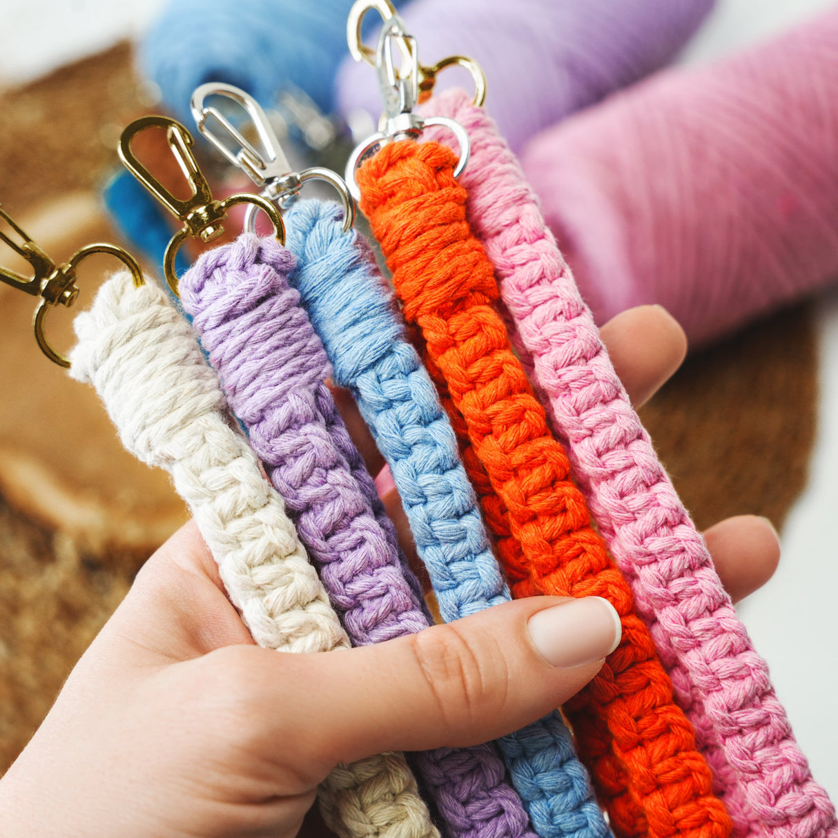 a person holding a row of crochet key chains
