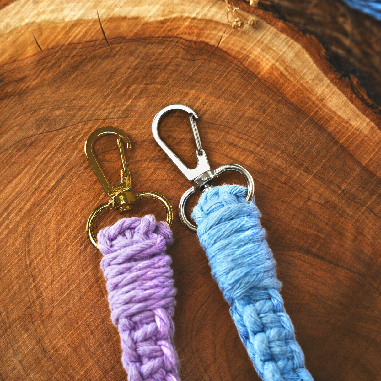 two crocheted key chains sitting on a piece of wood