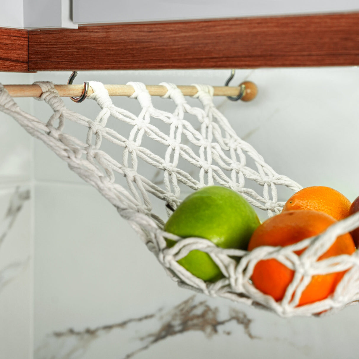 a white hammock filled with fruit sitting on top of a counter