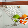 a white hammock filled with fruit sitting on top of a counter