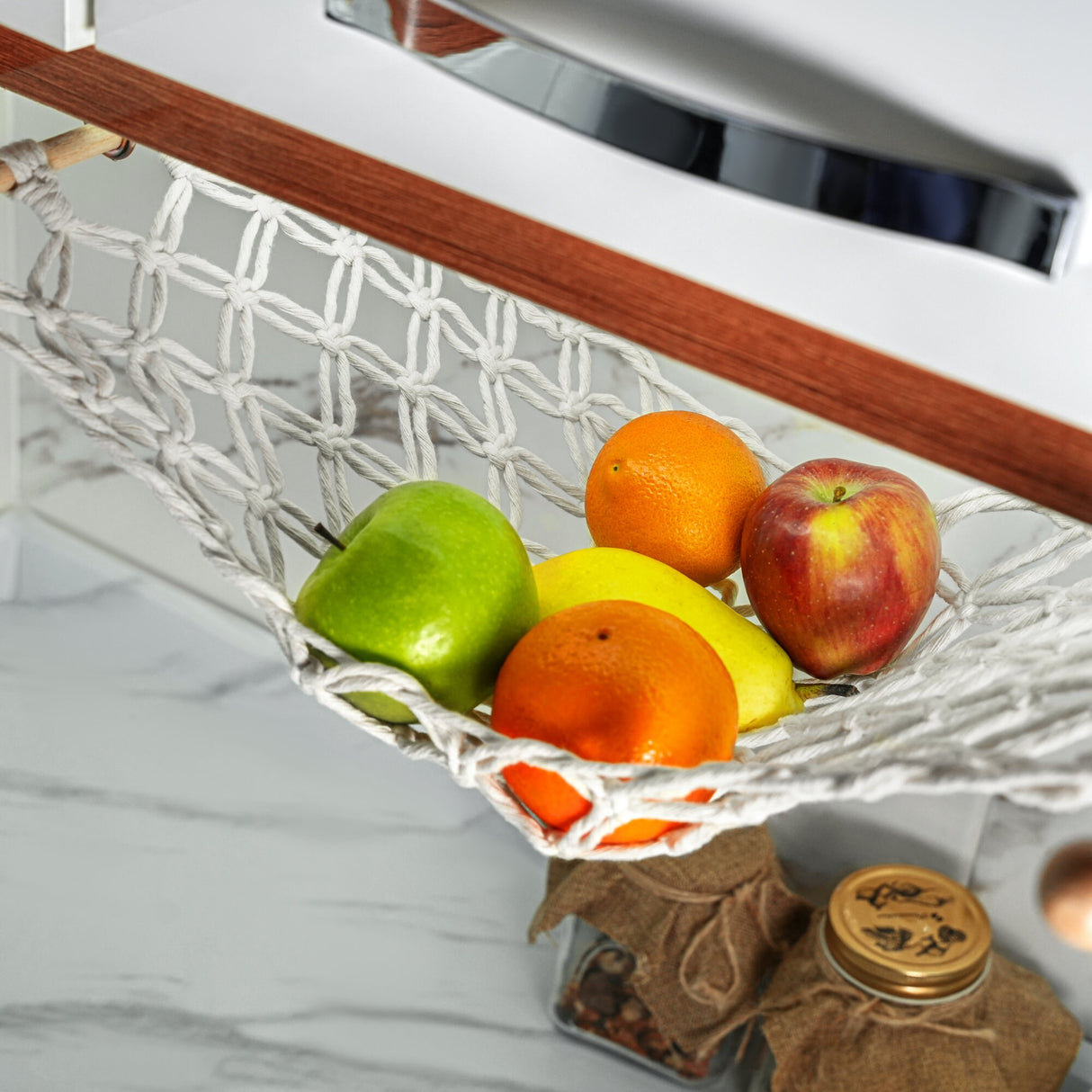 a white hammock filled with fruit on top of a counter