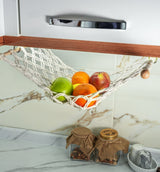 a hammock filled with fruit sitting on top of a counter