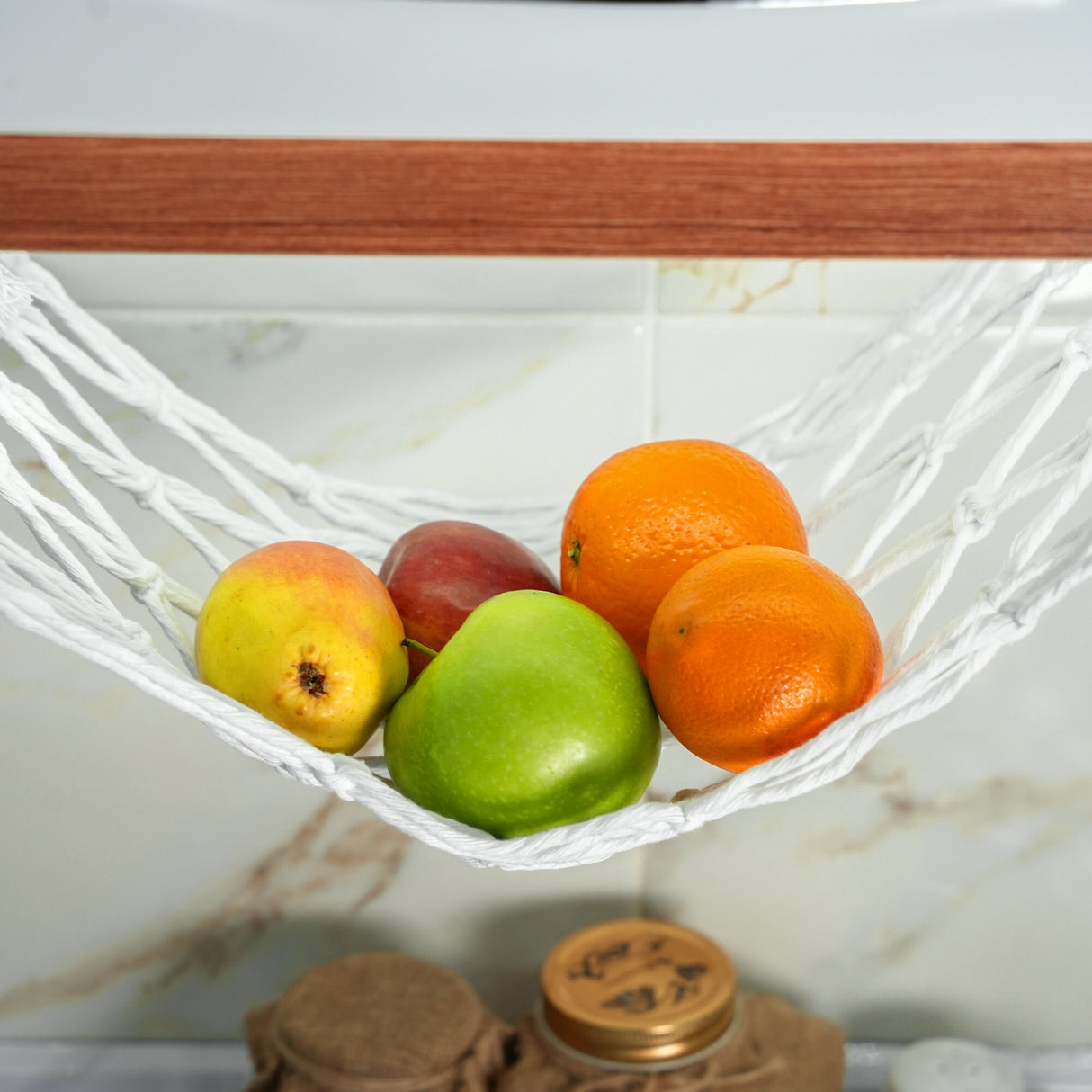 a white hammock filled with fruit on top of a counter