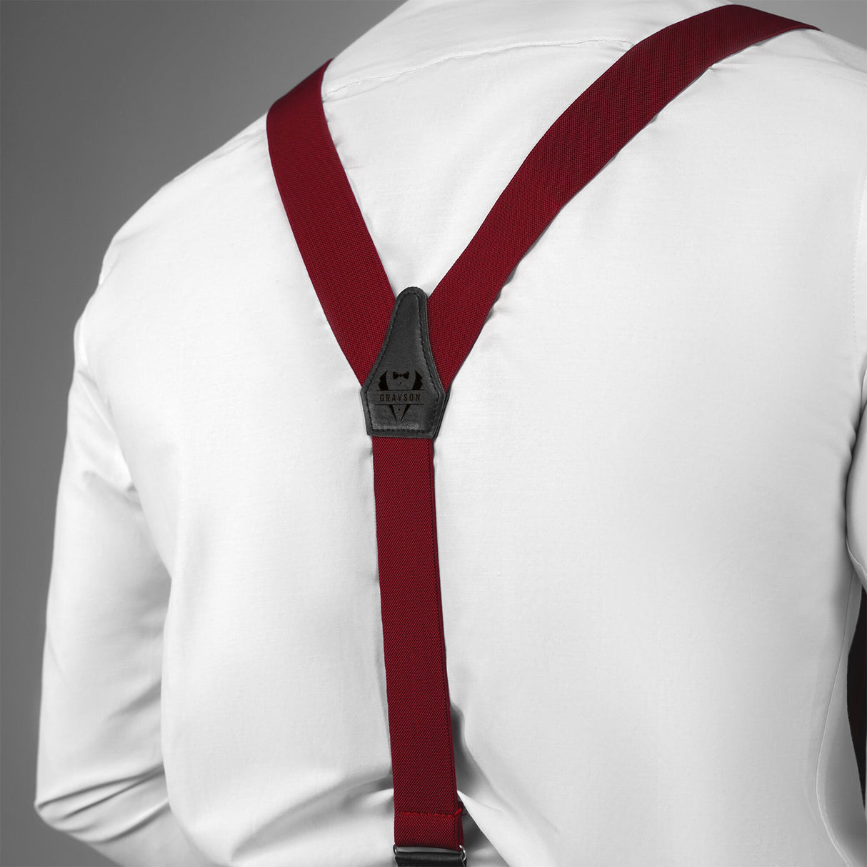 a man wearing a white shirt and red suspenders