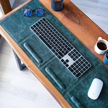 a desk with a keyboard, mouse and coffee cup