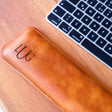 a leather case sitting next to a keyboard