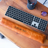 a keyboard and a leather case sitting on a table