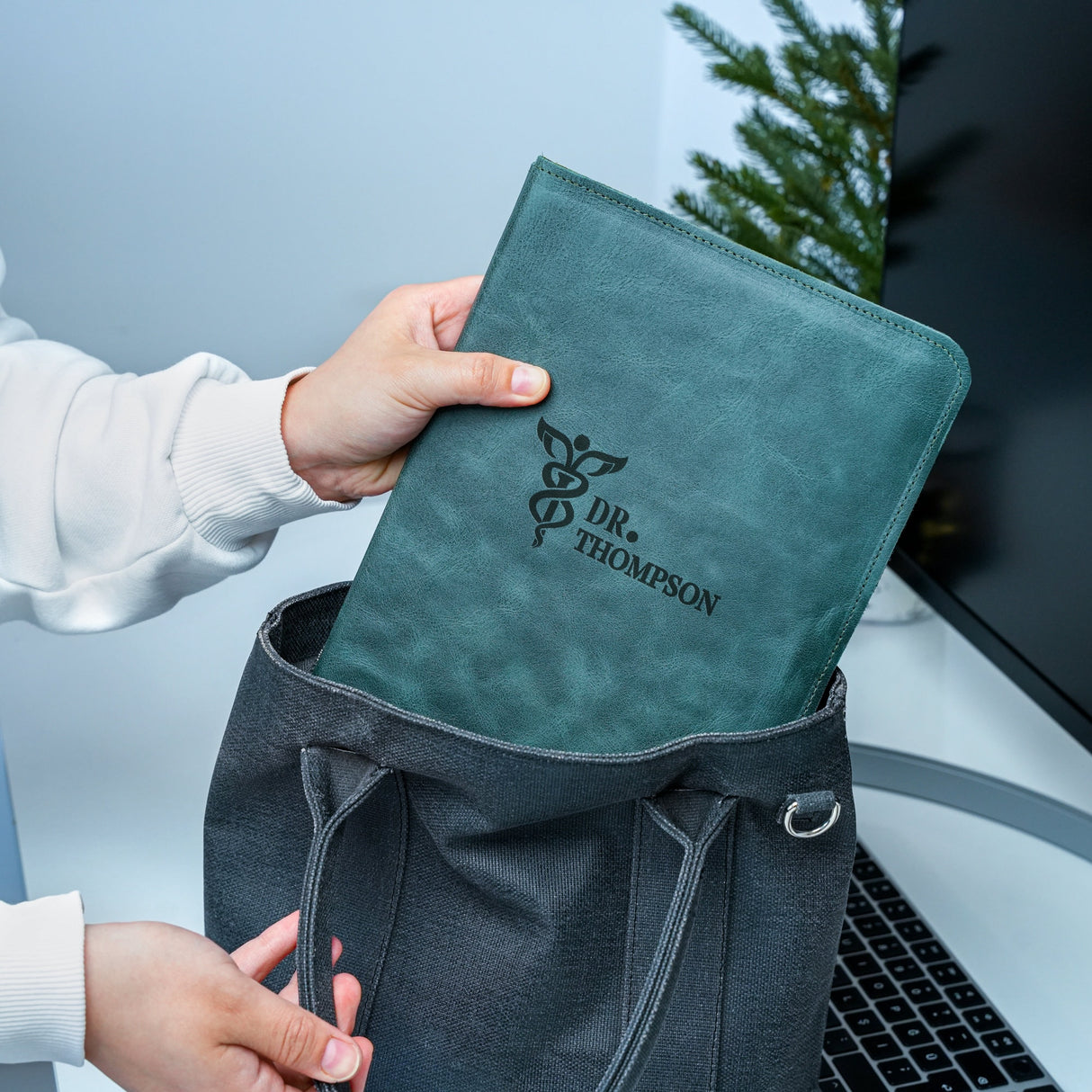 a person holding a green bag with a logo on it