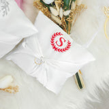 a white pillow with a monogrammed initial on it