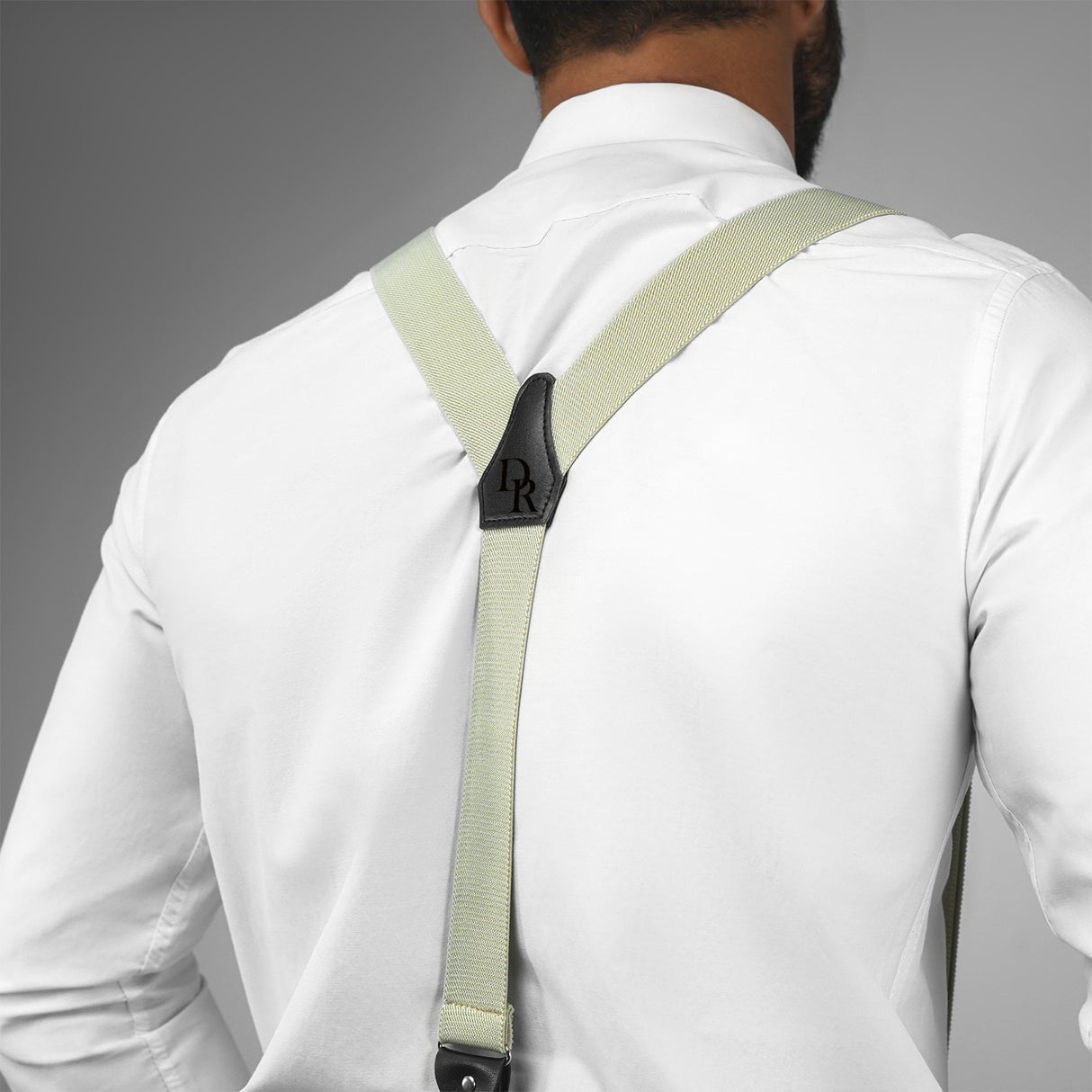 a man wearing a white shirt and green suspenders