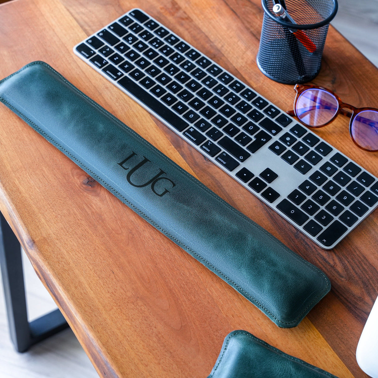 a keyboard and glasses on a wooden table